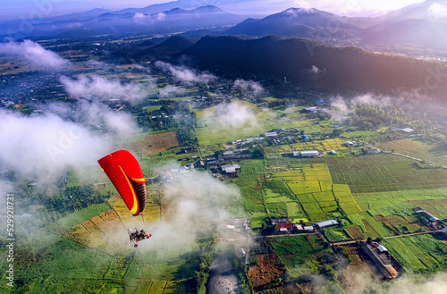 Challenge and freedom concept. red para motor on high blue sky with high panorama view of stunning landscape.