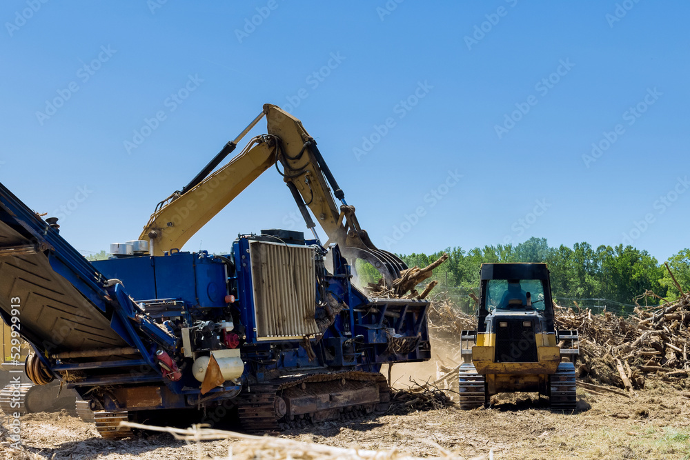 With the help an industrial shredder machine, we are shredding roots of roots on land being prepared for building housing developments