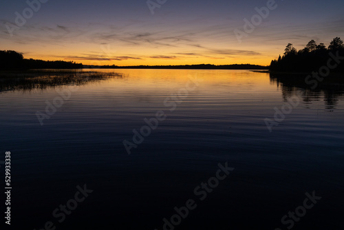 Fading sunset glow at dusk over northern lake scene for magazine newsletter advertising layout design