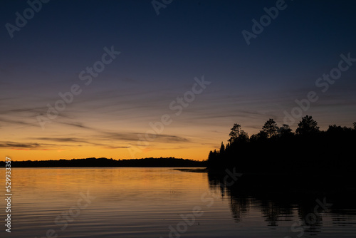 Fading sunset glow at dusk over northern lake scene for magazine newsletter advertising layout design