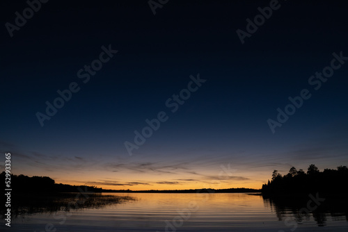 Fading sunset glow at dusk over northern lake scene for magazine newsletter advertising layout design