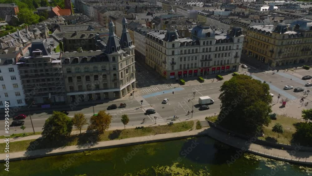 High angle view of busy crossroad in city. Descending tilt up reveal of cityscape with many towers. Copenhagen, Denmark High angle view of busy crossroad in city. Descending tilt up reveal of cityscape with many towers. Copenhagen, Denmark