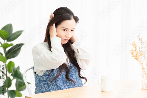 リビングで騒音に困っている女性