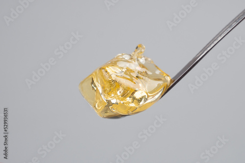 yellow clean cannabis wax, concentrate marijuana and dabbing tool close-up