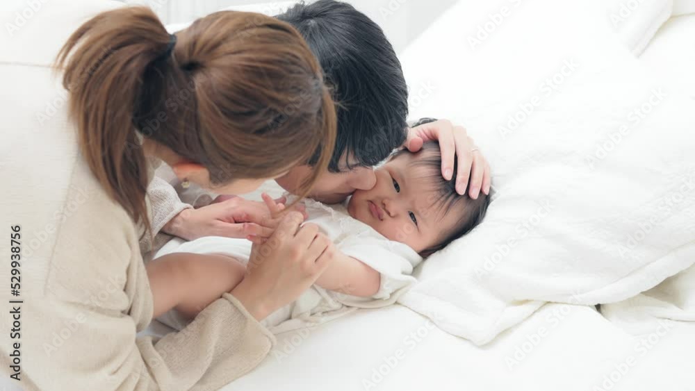 赤ちゃんを寝かしつける両親　子育てイメージ