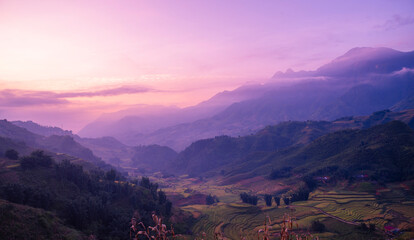 Fototapete Lila Dramatic sunset over mountain landscape. Beautiful landscape foggy hills twilight time. Blue golden sky sunrise dramatic beautiful landscape mountain. Dawn sky gold dusk time cloudscape with sunlight  © aFotostock