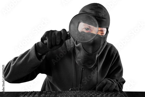 Male hacker using a magnifier to look at camera