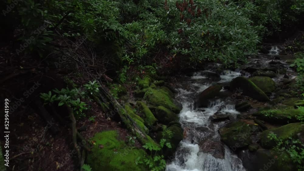 Pulling away from beautiful waterfall in tropical forest to reveal a platform with lawn chairs for sitting to observe and enjoy the nature
