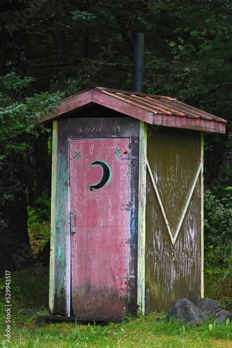 Old wooden outhouse in the forest near Seward, Alaska.