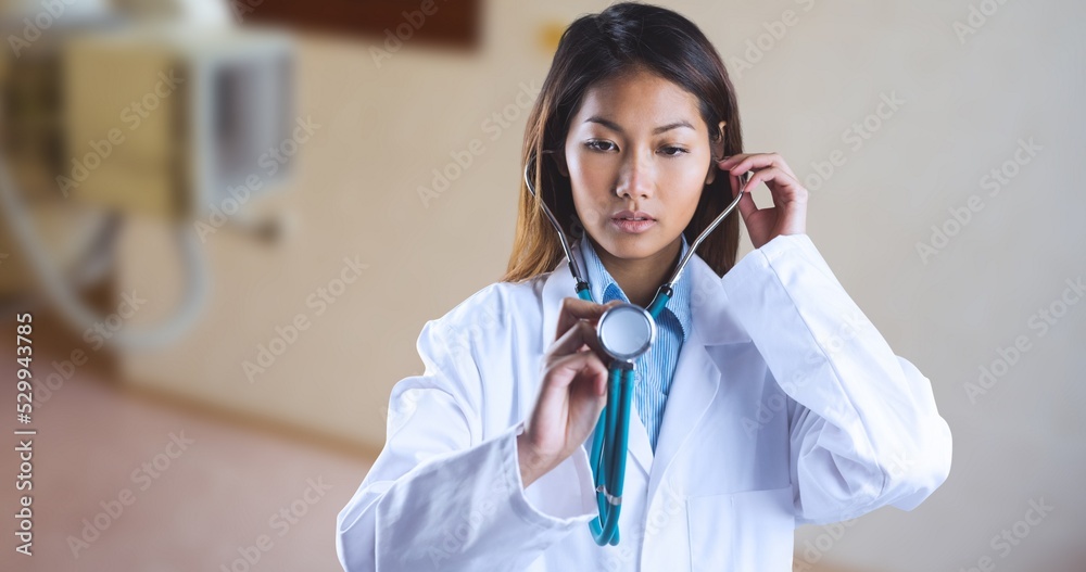 Asian young female doctor examining with stethoscope while standing in hospital Asian young female doctor examining with stethoscope while standing in hospital