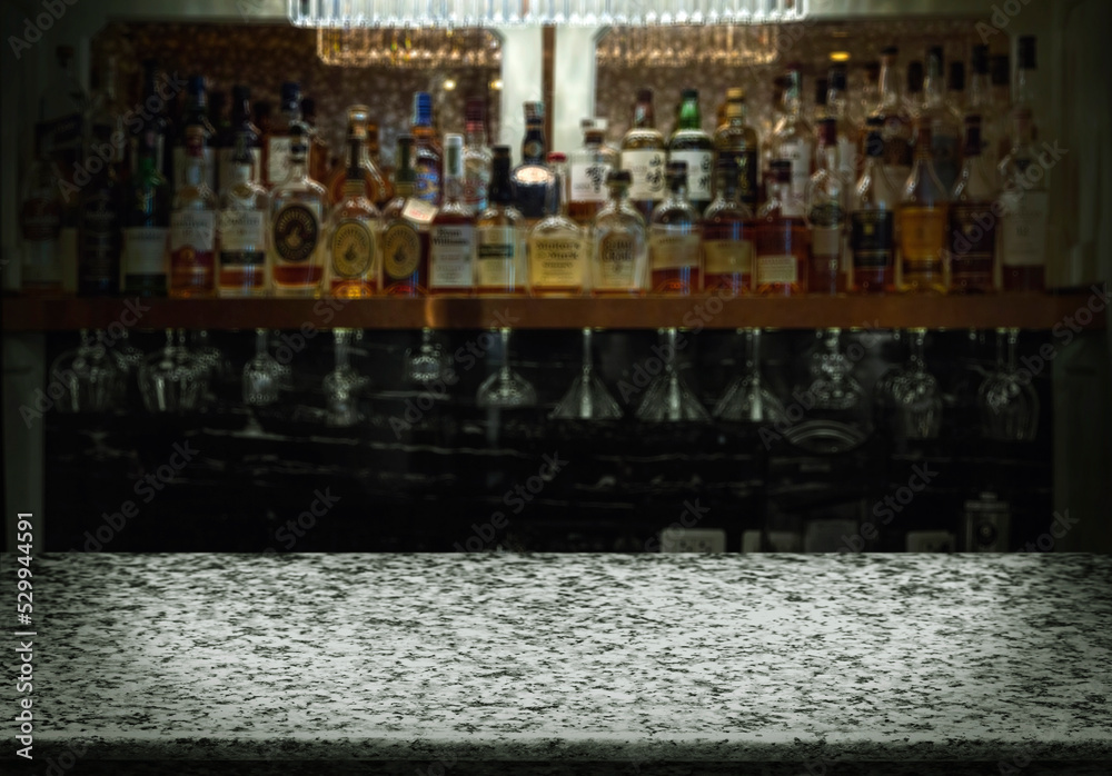 Empty marble bar counter with defocused background and bottles