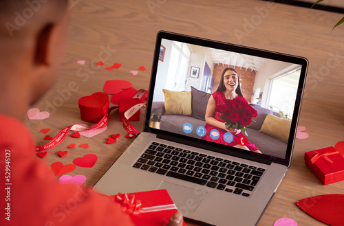 Biracial young woman holding bouquet online dating with boyfriend on valentine day