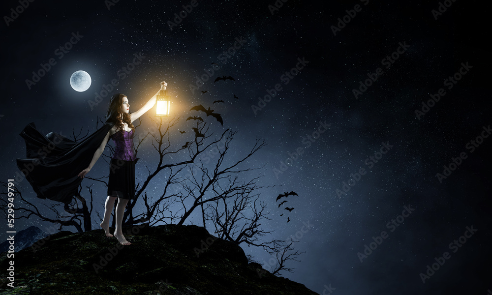Fototapeta premium Beautiful young woman in witches hat and costume