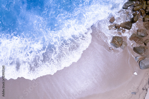 Aerial view waves crashing on sand of beach and soft wave background Top view
