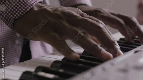 African American musician playing an old keyboard piano on stage. photo
