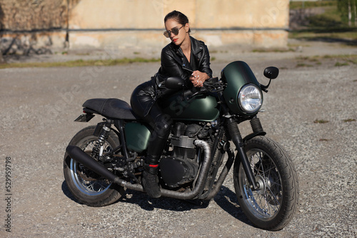 Portrait of young woman on a black motorcycle