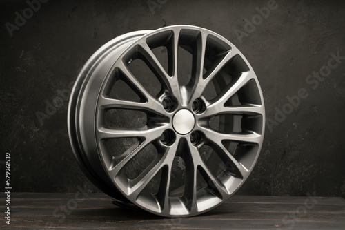 new grey alloy wheels on a dark textured black background. car wheel