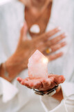 Self-esteem meditation. Hand holding a rose quartz crystal, boosting feeling of self-esteem and self-love, improving mood and harmony