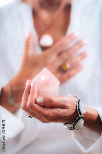 Self-esteem concept. Hand holding a rose quartz crystal, boosting feeling of self-esteem and self-love, improving mood and harmony photo