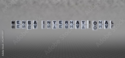 mensa international word or concept represented by black and white letter cubes on a grey horizon background stretching to infinity photo