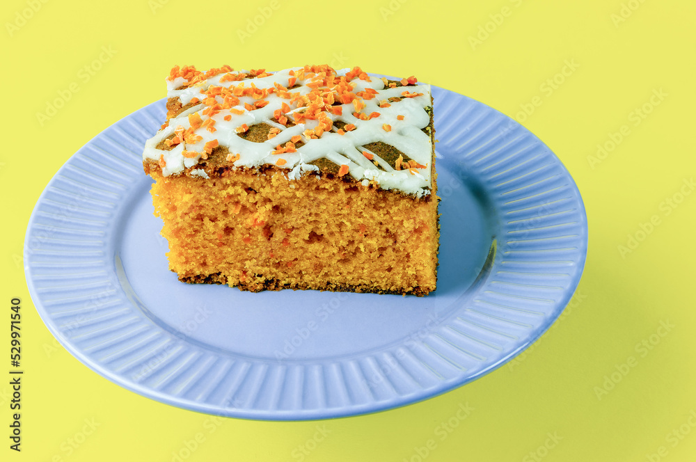 slice of carrot cake with white cream on a light yellow background slice of carrot cake with white cream on a light yellow background