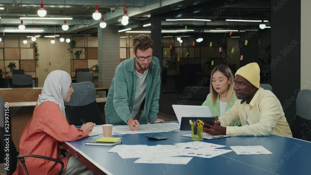 Male Caucasian leader discusses a project with his colleagues.Different Races,Diverse People,Creative Team,Business Partners Male Caucasian leader discusses a project with his colleagues.Different Races,Diverse People,Creative Team,Business Partners