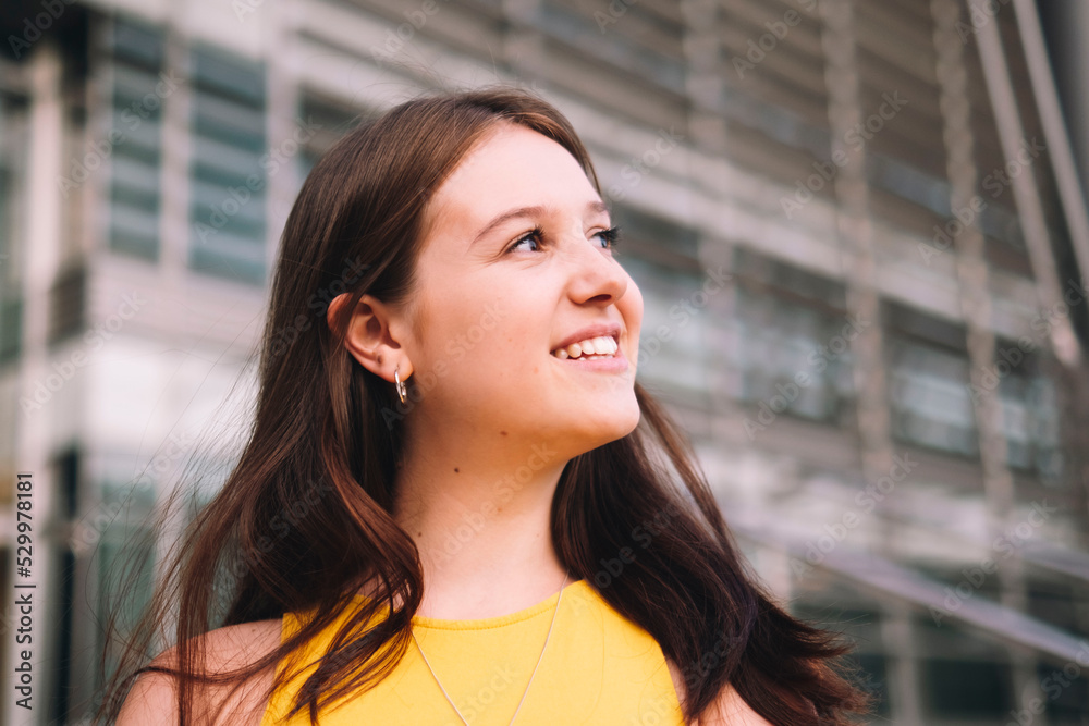 Thoughtful smiling woman standing outside building Thoughtful smiling woman standing outside building