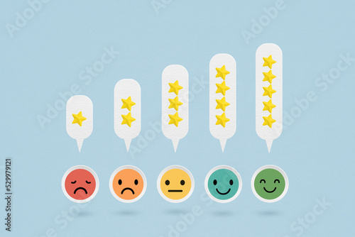 For customer services best excellent business rating experience. Satisfaction survey concept.  Emotion face on grunge white paper cut with rating stars photo