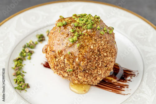 Fried ice cream sprinkled with peanuts on a white porcelain plate