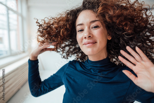Smiling young woman tossing hair photo