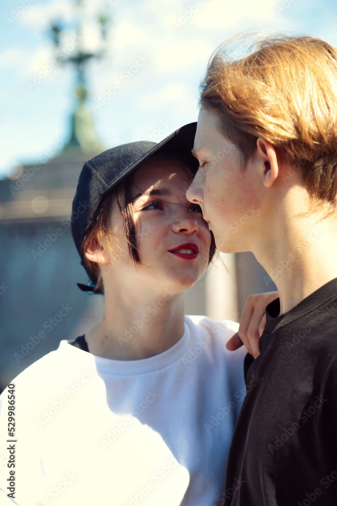 A young couple of teenagers are happy together and want love. First kiss. Girl in a cap A young couple of teenagers are happy together and want love. First kiss. Girl in a cap