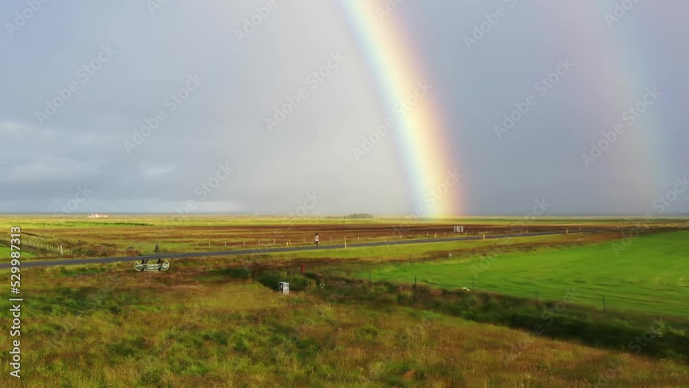 person running on an empty street with a rainbow in the background
