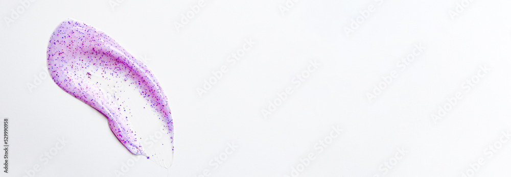 Purple cream scrub for washing. An exfoliating skin care product. White background. Copy space.