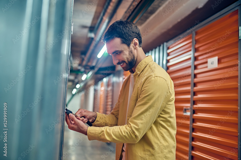 Man concentrated on padlocking the storage unit door Man concentrated on padlocking the storage unit door