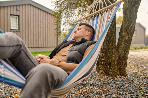 Male vacationer sleeping in the hammock outdoors