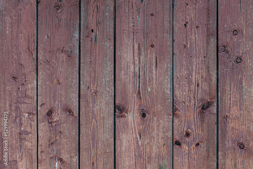 Brown vertical planks with knots and chipped away paint