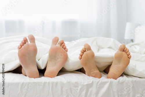 relationship, lifestyle and relaxation concept - male and female legs under blanket