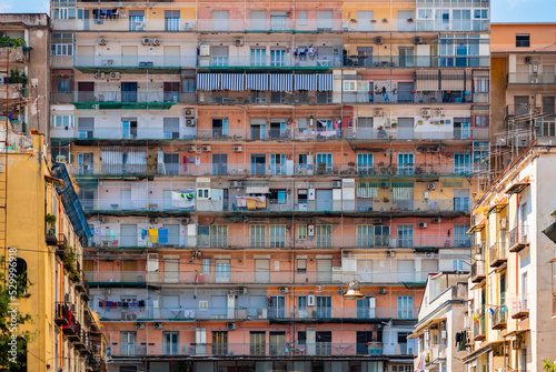 Colorful facade of a big block of flats in the old town “Centro storico“ of italian metropole Naples. Rows of balconys in over 10 floors high building near central station. Rotten old tenement house. © ON-Photography