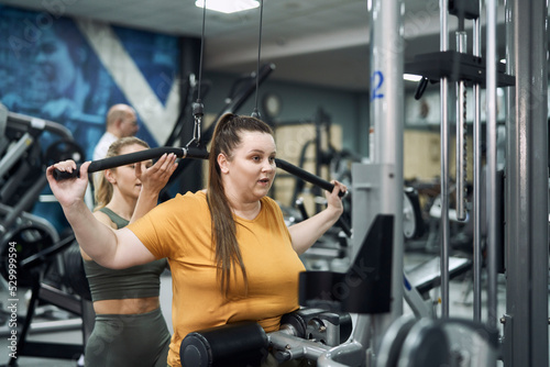 Caucasian woman with overweight training at the gym