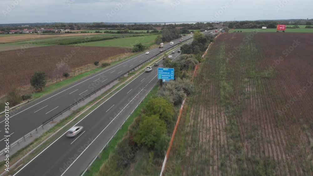 Aerial Lifting Drone View Showing Of Busy Hungarian Highway, Beautiful Lake In The Background Aerial Lifting Drone View Showing Of Busy Hungarian Highway, Beautiful Lake In The Background