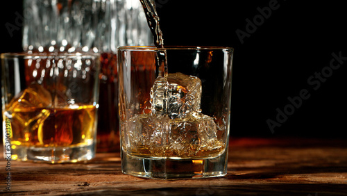 Detail of pouring whisky into glass. #530003981