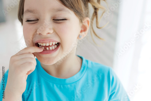 The child has lost a tooth. Little girl without a tooth. The first tooth fell out. High quality photo