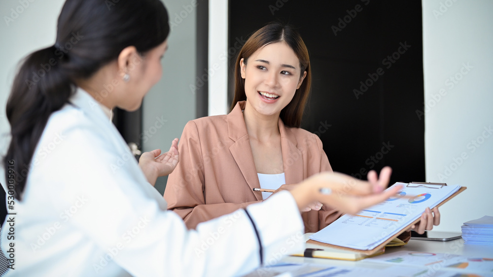 A talented Asian female financial analyst presenting her financial investment plan to her boss A talented Asian female financial analyst presenting her financial investment plan to her boss
