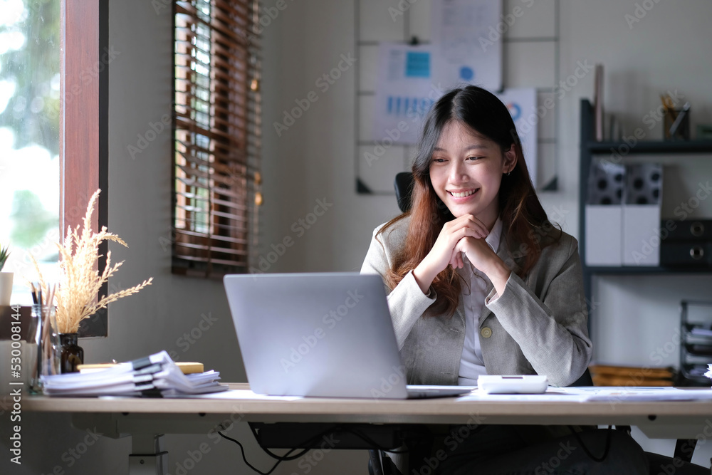 Beautiful young asian woman sitting at coffee shop using laptop. Happy young businesswoman sitting at table in cafe with tab top computer. Beautiful young asian woman sitting at coffee shop using laptop. Happy young businesswoman sitting at table in cafe with tab top computer.