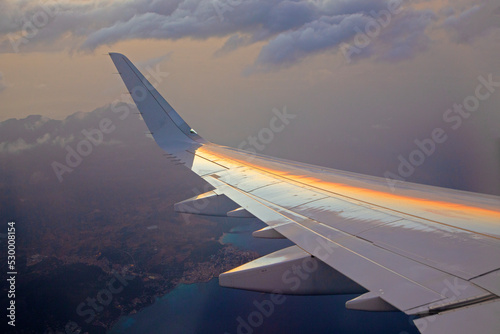 sunset seen from aircraft with reflection of sun in wing