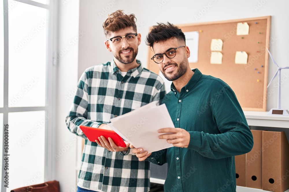 Young couple business workers using touchpad reading document working at office Young couple business workers using touchpad reading document working at office