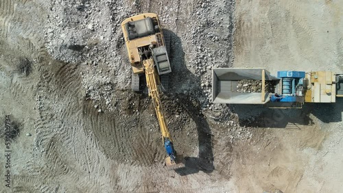 Construction excavator works at the industrial quarry that loads earth, sand and stones. photo