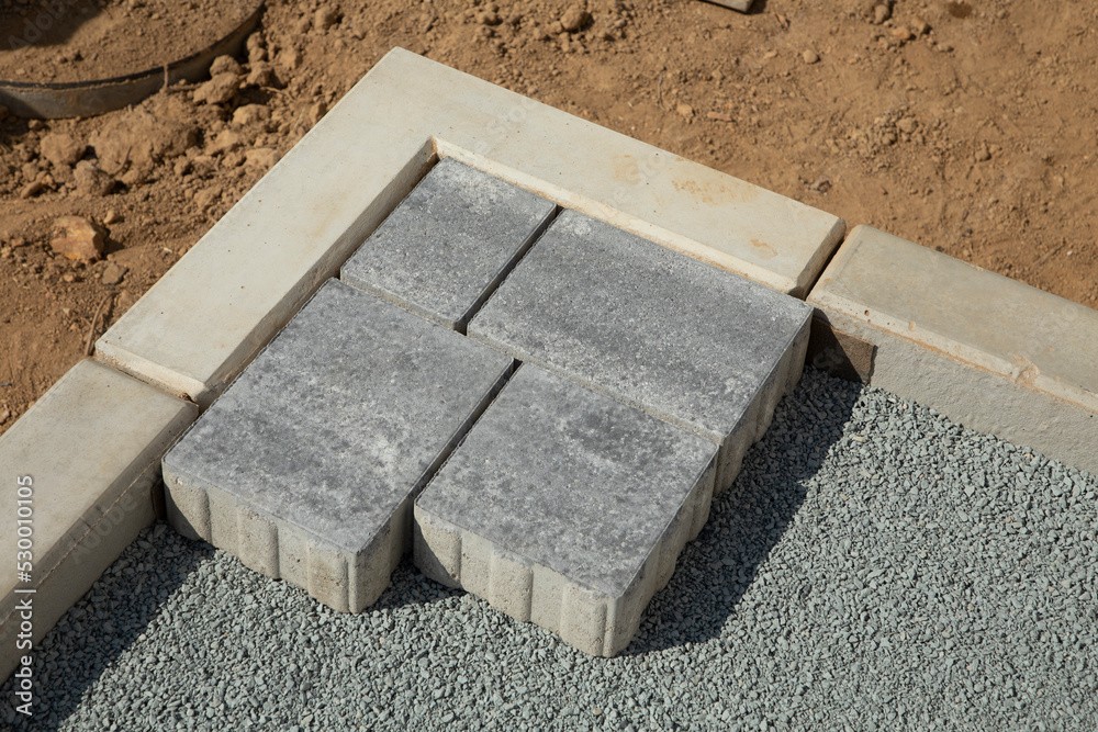 Laying gray concrete paving slabs in the courtyard of the house on a sandy foundation. Laying gray concrete paving slabs in the courtyard of the house on a sandy foundation.