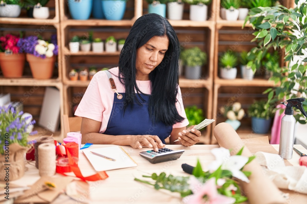 Middle age hispanic woman florist counting dollars at florist Middle age hispanic woman florist counting dollars at florist