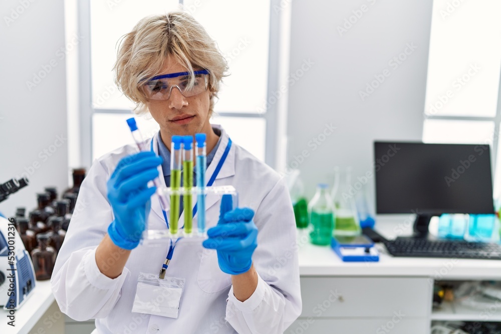 Young blond man scientist holding test tubes at laboratory Young blond man scientist holding test tubes at laboratory